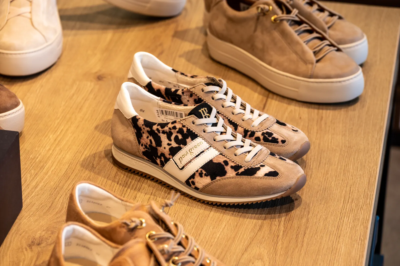 Sneaker mit Fellmuster auf einem Holztisch